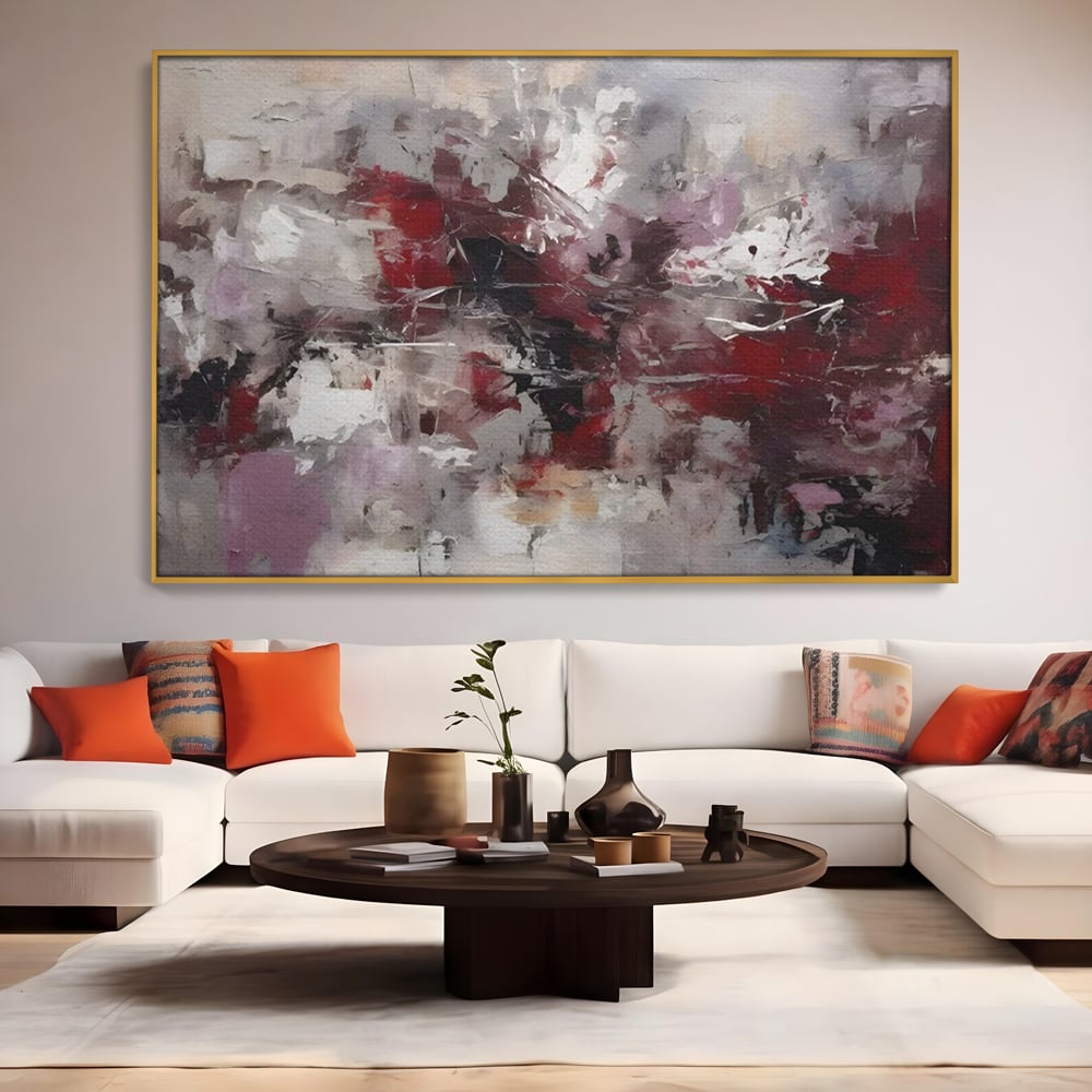 Tablou canvas cu pictura abstracta cu pete rosii, in rama de aluminiu auriu, pe perete intr-un living